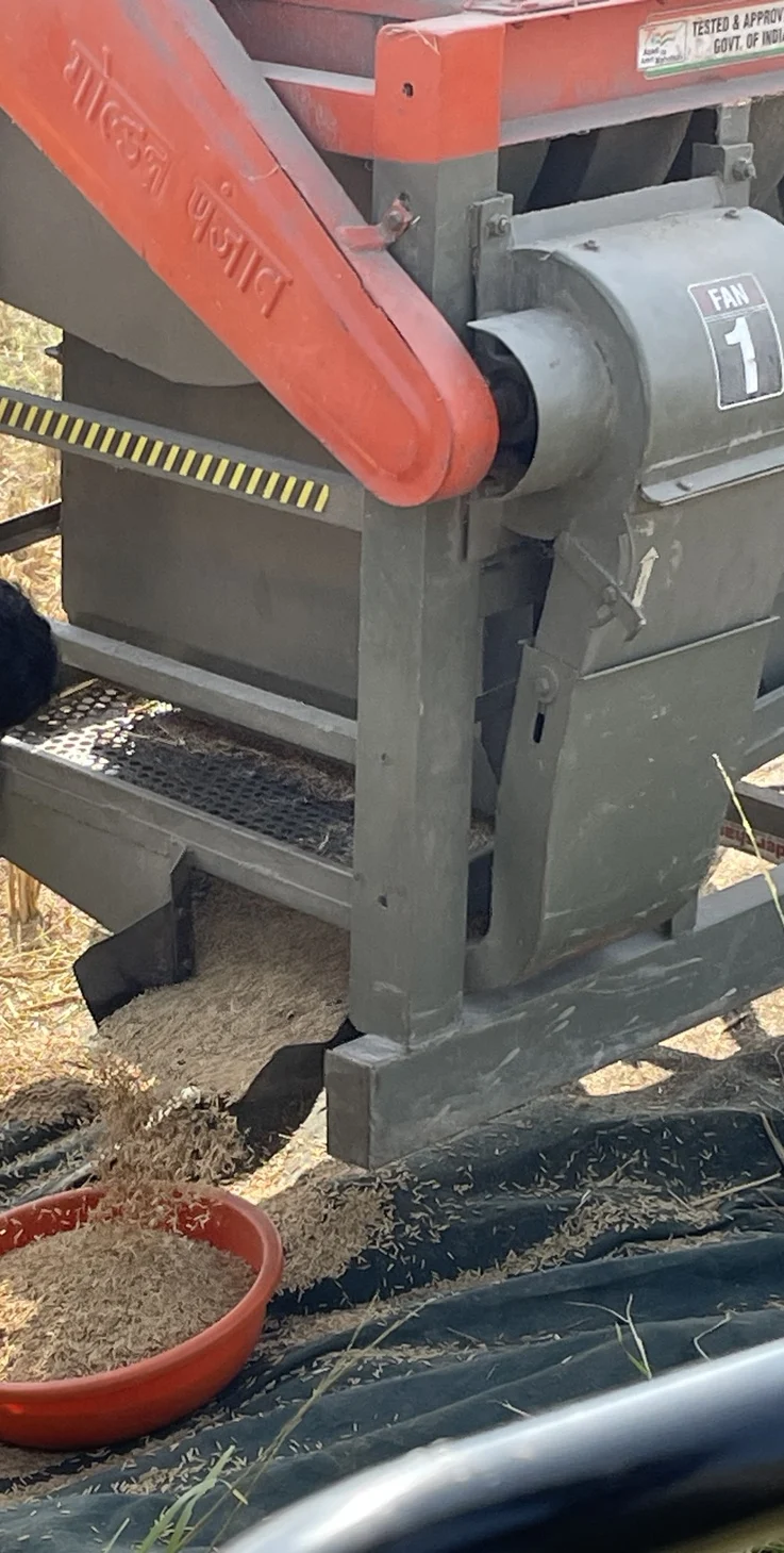 An outlet and collection point on farm threshing equipment.