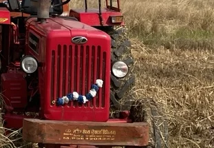 A tractor seen close to the field edge.